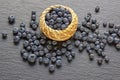 Fresh ripe whortleberries in small basket on black table Royalty Free Stock Photo