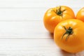 Fresh ripe yellow tomatoes on white wooden table, closeup. Space for text Royalty Free Stock Photo