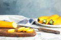 Fresh ripe yellow zucchinis on marble table against background, space for text