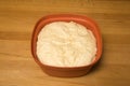 fresh risen yeast dough in a red bowl on a wooden table background Royalty Free Stock Photo