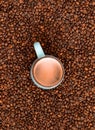 Fresh roasted coffee beans background with cup of coffee. Top view. Royalty Free Stock Photo