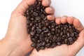 Fresh roasted coffee beans pouring in heart hands Royalty Free Stock Photo