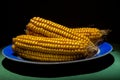 Fresh roasted or grilled corncobs with butter melting over the succulent kernels served on a rustic metal plate Royalty Free Stock Photo