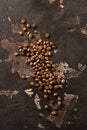 Fresh Roasted whole grains of Arabica coffee scattered on an old brown textured background.