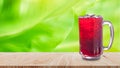 Fresh Roselle juice sweet water and iced in glass on wooden table with nature background, Summer health drinks with ice, Red juice Royalty Free Stock Photo