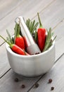 Fresh rosemary herb and red pepper in metal mortar with pestle Royalty Free Stock Photo