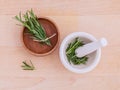 Fresh rosemary herbal medicine in mortar and wooden bowl on wooden table Royalty Free Stock Photo