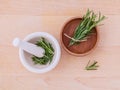 Fresh rosemary herbal medicine in mortar and wooden bowl on wood Royalty Free Stock Photo