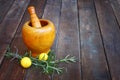 Fresh rosemary herbs in wooden pestle and mortar on wooden table Royalty Free Stock Photo