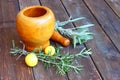 Fresh rosemary herbs in wooden pestle and mortar on wooden table Royalty Free Stock Photo