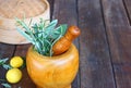 Fresh rosemary herbs in wooden pestle and mortar on wooden table Royalty Free Stock Photo