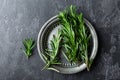 Fresh rosemary twigs on dark culinary background, top view, flat lay