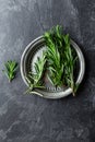 Fresh rosemary twigs on dark culinary background, top view, flat lay