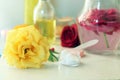 Fresh roses, soap, petals, water and oil on the table