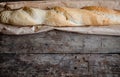 Fresh rosy baguettes on a dark wooden retro background. Top view, copy space