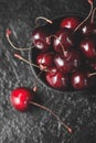Fresh ruby cherries on black slate background. Flatlay. Dark moody close up still life Royalty Free Stock Photo