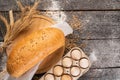 Fresh rural bread loaf with spikelets of wheat on a wooden background