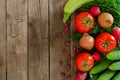 Fresh rustic vegetables on an old wooden table - tomatoes, cucumbers, onions, dill, beans, radishes