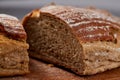 Fresh rye bread loaf on a wooden chopping board over white textured background, shallow depth of field Royalty Free Stock Photo