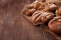 Fresh rye bread on the wooden table, wheat, paper bags, ears of wheat, rope and burlap Royalty Free Stock Photo
