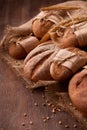 Fresh rye bread on the wooden table, wheat, paper bags, ears of wheat, rope and burlap. Vertical photo. Royalty Free Stock Photo