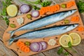 Fresh saira fish and ingredients for cooking on wooden background Royalty Free Stock Photo