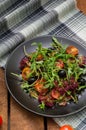 Fresh salad with arugula, shrimp, cherry tomato and avocado. Wooden background. Close-up. Top view