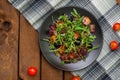 Fresh salad with arugula, shrimp, cherry tomato and avocado. Wooden background. Close-up. Top view