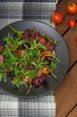 Fresh salad with arugula, shrimp, cherry tomato and avocado. Wooden background. Close-up. Top view