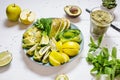 Fresh salad with avocado, kiwi, apple, cucumber, pear, lime and mint with smoothie on white wooden background. Healthy food, Royalty Free Stock Photo