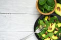 Fresh salad with avocado, spinach, pomegranate and walnuts in black plate with fork. healthy food Royalty Free Stock Photo