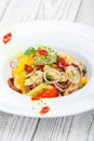 Fresh salad with avocado, sun dried tomatoes, hot peppers, cherry tomatoes, sweet peppers and onion on wooden background Royalty Free Stock Photo