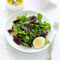 Fresh salad with beetroot, mix leaves, olive oil, egg and sesame seeds Royalty Free Stock Photo