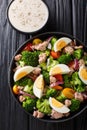 Fresh salad with canned tuna, broccoli, tomatoes, onions and eggs close-up in a plate. Vertical top view Royalty Free Stock Photo
