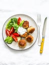 Fresh salad and canned tuna potato fish balls with greek yogurt cilantro sauce on light background, top view