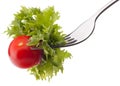 Fresh salad and cherry tomato on fork isolated on white background cutout. Royalty Free Stock Photo