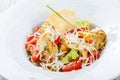 Fresh salad with chicken breast, artichokes, cherry tomatoes, lettuce and cheese parmesan on wooden background close up Royalty Free Stock Photo