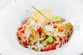 Fresh salad with chicken breast, artichokes, cherry tomatoes, lettuce and cheese parmesan on wooden background close up Royalty Free Stock Photo