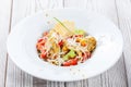 Fresh salad with chicken breast, artichokes, cherry tomatoes, lettuce and cheese parmesan on wooden background close up