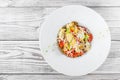 Fresh salad with chicken breast, artichokes, cherry tomatoes, lettuce and cheese parmesan on wooden background close up.