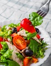 Fresh salad with chicken breast, arugula, black olives,red pepper, lettuce, fresh sald leaves and tomato on a white plate on woode Royalty Free Stock Photo