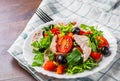 Fresh salad with chicken breast, arugula, black olives,red pepper, lettuce, fresh sald leaves and tomato on a white plate on woode Royalty Free Stock Photo