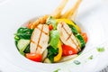 Fresh salad with chicken breast, baby spinach, basil, cherry tomatoes, pear, cucumber on plate on wooden background Royalty Free Stock Photo