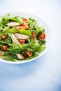 Fresh salad with chicken, tomato and greens (spinach, arugula) on blue wooden background close up Royalty Free Stock Photo