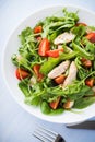 Fresh salad with chicken, tomato and greens (spinach, arugula) on blue wooden background top view Royalty Free Stock Photo