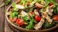Fresh salad with chicken, tomatoes, and mixed greens on wooden background, close-up Healthy eating