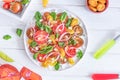 Fresh salad with colorful tomatoes, cheese, onion and spinach on a white background. Top view Royalty Free Stock Photo