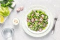 Fresh salad of cucumbers, radishes, green peas and herbs in white bowl. Flat lay Royalty Free Stock Photo