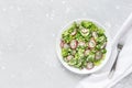 Fresh salad of cucumbers, radishes, green peas and herbs in white bowl. Top view Royalty Free Stock Photo