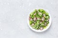 Fresh salad of cucumbers, radishes, green peas and herbs in white bowl. Top view Royalty Free Stock Photo